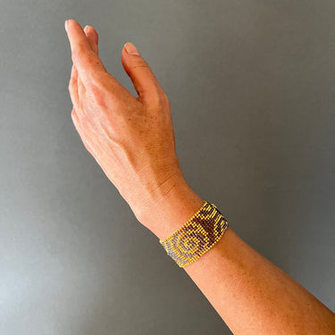 Brazalete Telar Dorado Medio Espirales Gris Traslúcido